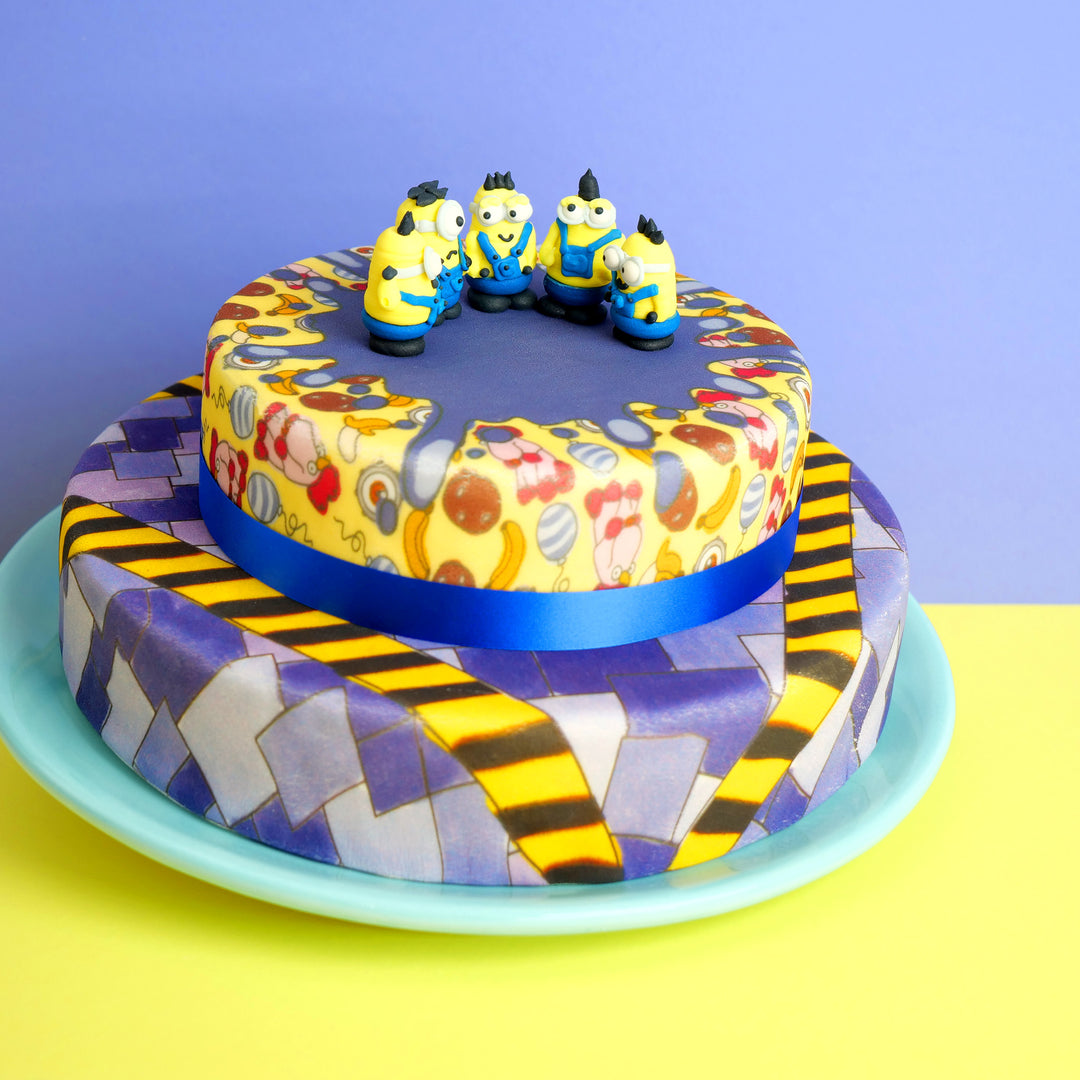 Minions® op een tweelaagse schurkachtige patroontaart