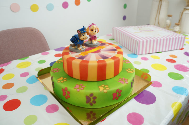 Paw Patrol® op een 2-laags roze hondenpoot taart