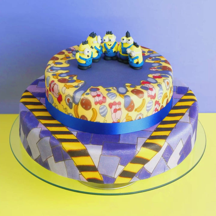 Minions® op een tweelaagse schurkachtige patroontaart